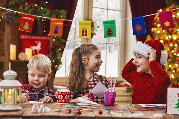 Three children making Christmas crafts