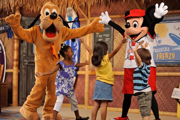 Goofy and Mickey Mouse with three yong children on stage
