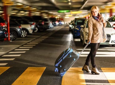 lady with suitcase in airport parking lot